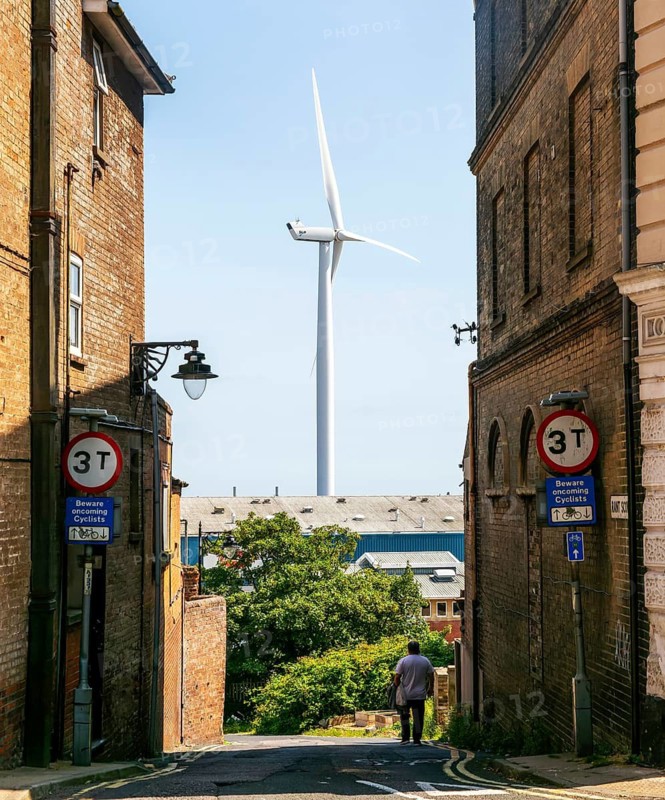 Large wind turbine 'Gulliver' seen through buildings at Rant Score, Lowestoft, Suffolk, England, UK