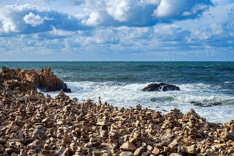 Picturesque coastal landscape full of stone men, near Hovs Hallar, a nature reserve near Bastad, Skåne, Sweden. Picturesque coastal scenery dotted with cairns, at Hovs Hallar, a nature reserve near Bastad, Scania, Sweden