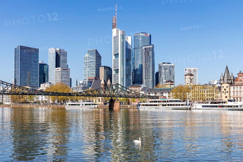 Frankfurt skyline skyscrapers with banks on the river Main with excursion boats and Eiserner Steg in Frankfurt, Germany