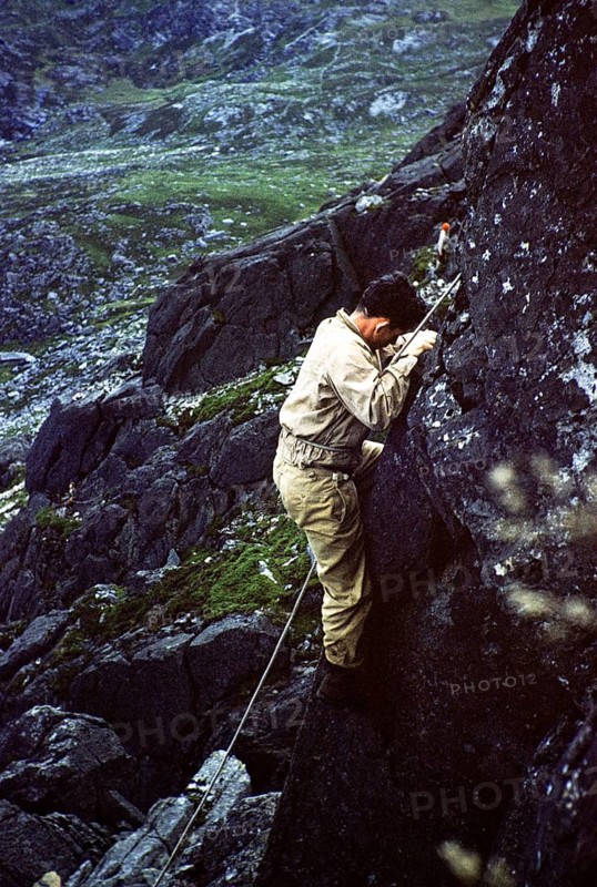 Young male climber on a rock face with climbing rope, probably North Wales, Great Britain around 1958