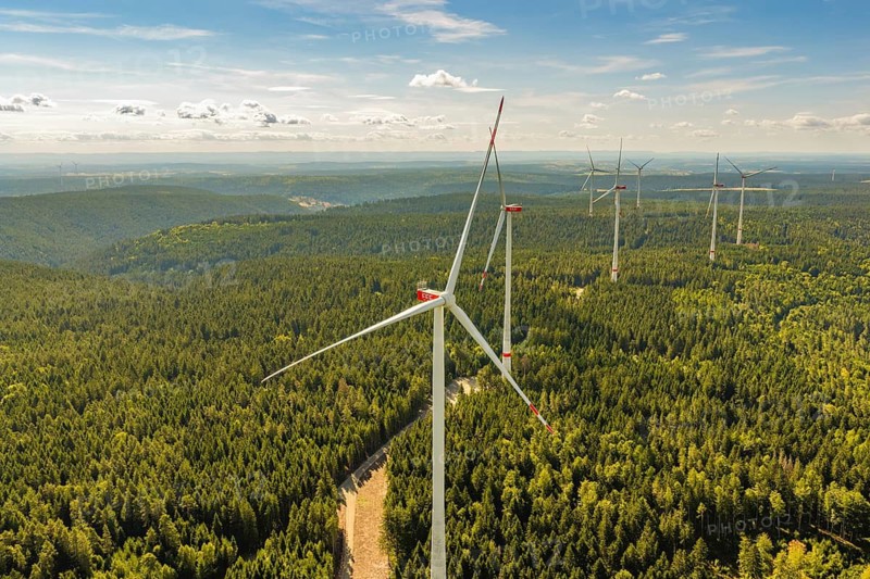 Large wind turbines on a wooded hill that stretches to the horizon, Besenfeld, Freudenstadt district, Germany
