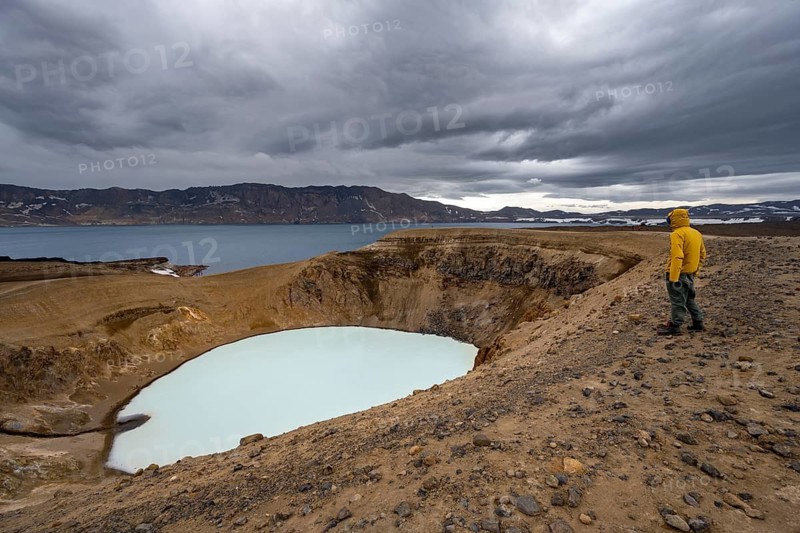Tourist at the crater rim, crater lake Víti and Öskjuvatn in the crater of Askja volcano, volcanic landscape, mountain massif Dyngjufjöll, Icelandic highlands, Vatnajökull National Park, Iceland