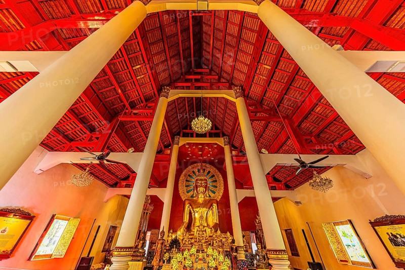 Gilded Buddha statue in a public prayer hall in the Wat Phra Singh Buddhist temple complex, Chiang Mai Old City Center, Chiang Mai Province, Thailand