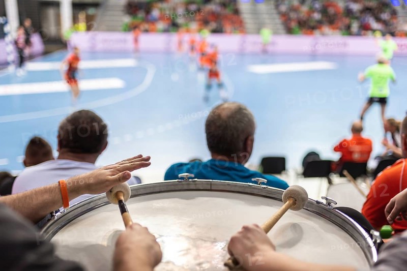 Supporters drum during handball match.