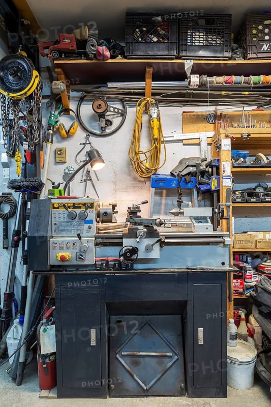 Craftex metal lathe machine with various objects, items and parts hanging on wall and on wooden shelves in home garage workshop, Quebec, Canada