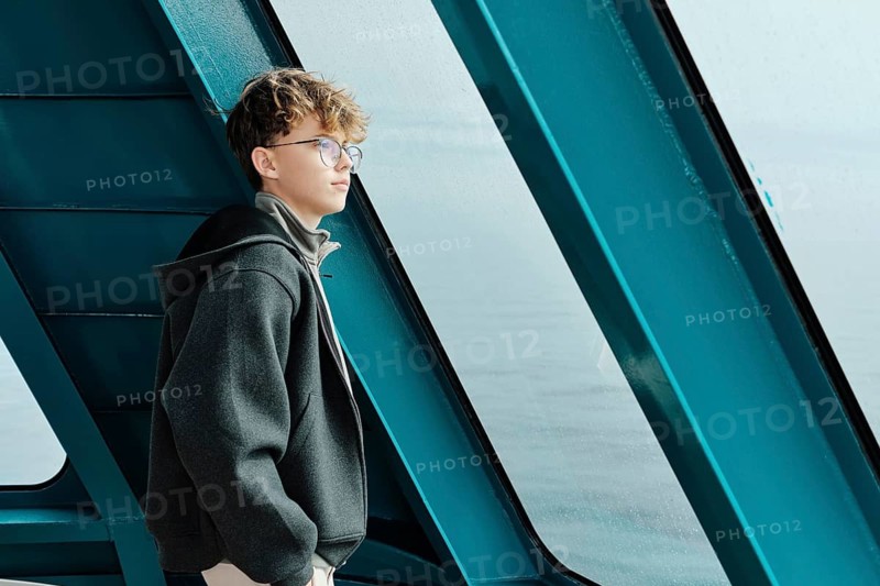 A thoughtful teenager gazes out of a window at Astun ski resort, located in the Huesca Pyrenees. The serene setting captures a moment of introspection and tranquility