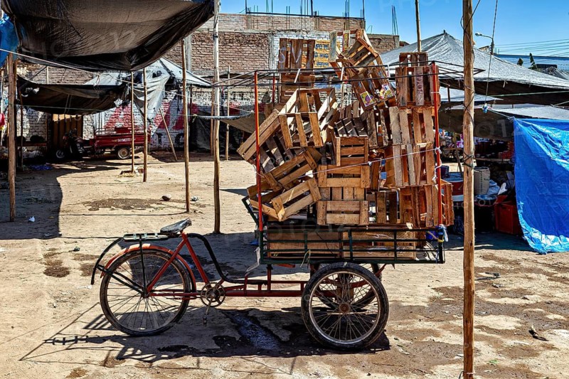 Empty tricycle loaded with wooden boxes at a quiet market, market and market stalls in the streets of Nasca in Peru