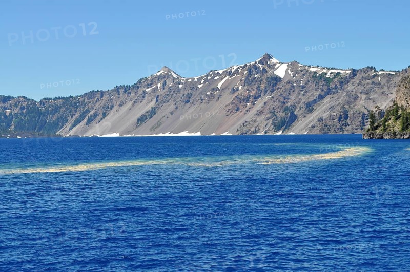 View of Crater Lake's deep blue water and snow-capped mountain peaks, Crater Lake National Park, Oregon, USA