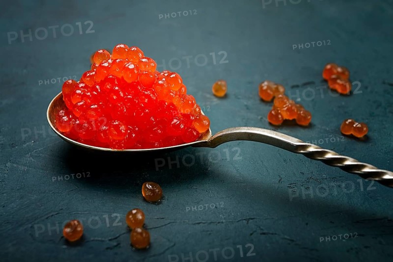 Spoons with red caviar, imitation, on a dark background, no people