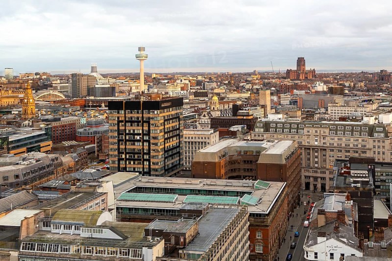 View over city centre rooftops to the Anglican cathedral, Liverpool, England, UK