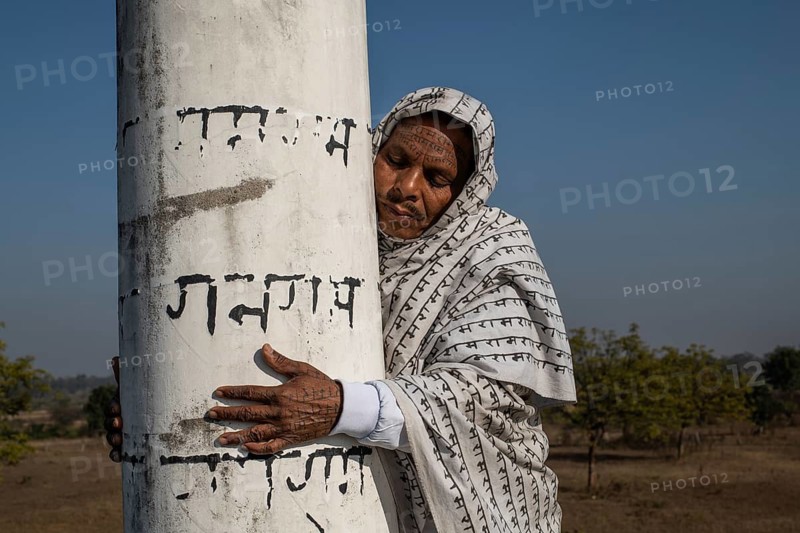 Man from the Ramnami community hugging the pillar of a Ramnami place of worship as a sign of devotion (Chhattisgarh, India), As a sign of devotion, Ramnami people used to tattoo their body and face with the name of Rama, one of the main hindu god. Nowadays, this tradition is disappearing. Indeed, few of them are still tattooed, the younger generation fearing discrimination. The community (or sect) is born in the end of the 19th century asa way to protest against the supremacy of the higher classes in the hindu hierarchical system. Comprised of low caste hindus, they dont accept the caste system, they practise a form of bhakti (devotion) dedicated to the god Rama