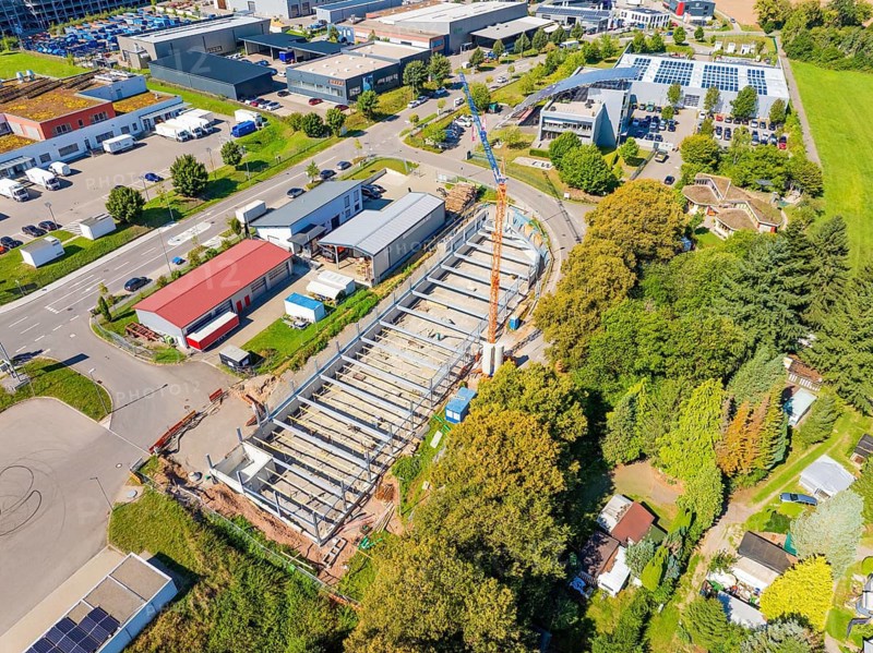 Aerial view of a construction site with a crane in the midst of urban buildings and green spaces, parking garage construction, Calw, Germany