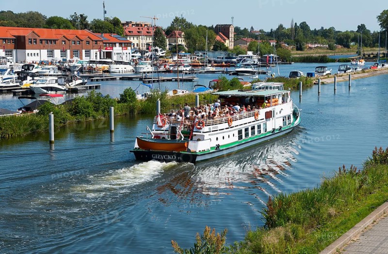 A passenger ship full of people sails through a lake in a coastal town, Gizycko, Warminsko-Mazurskie, Warmia-Mazurskie, Poland