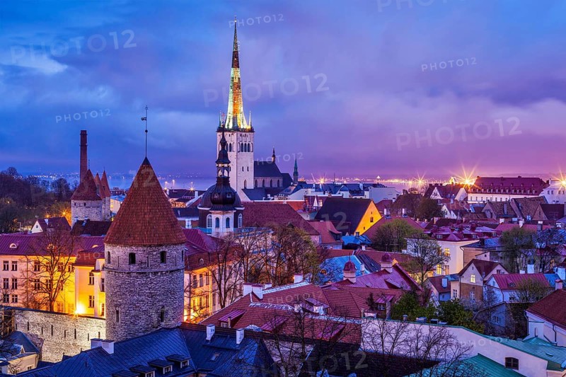 Aerial view of Tallinn Medieval Old Town illuminated in evening twilight, with dramatic sky Estonia