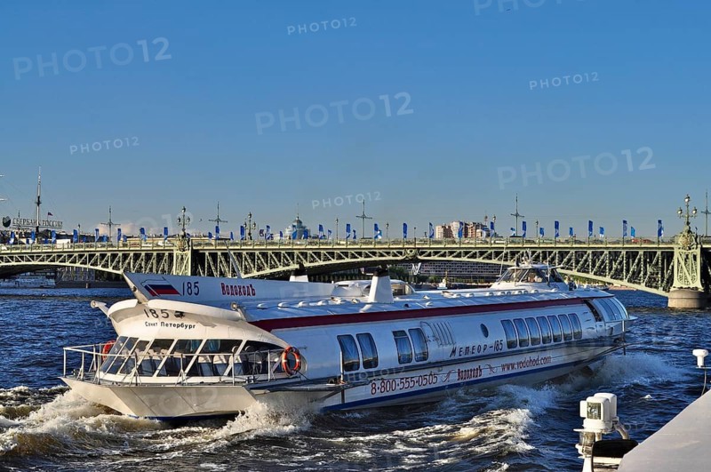 A speedboat, hydrofoil Meteor, travels near a bridge on a river in the city, Saint Petersburg, St. Petersburg, Russia