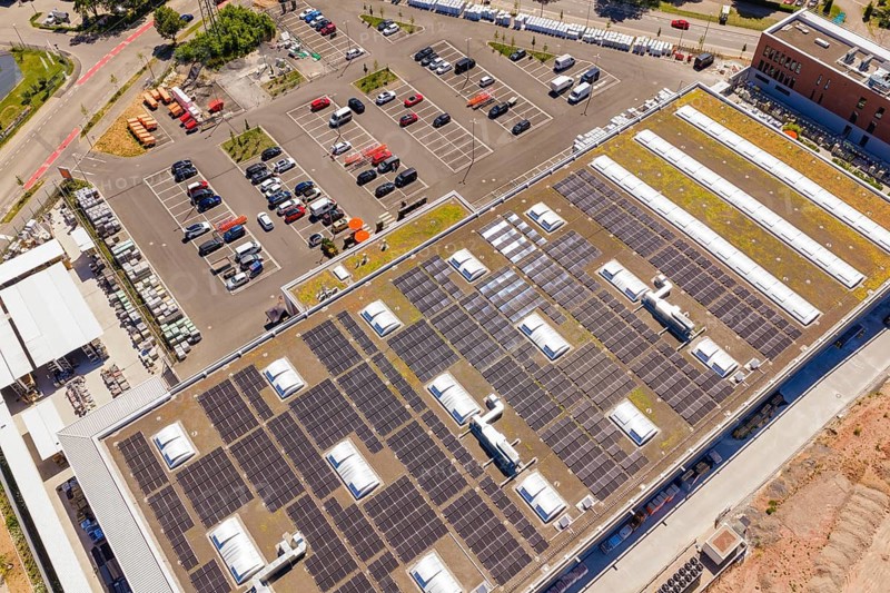 Large roof with solar panels in an urban environment, next to numerous cars in a parking lot, PV system at OBI Baumarkt, Mühlacker, Enzkreis, Germany