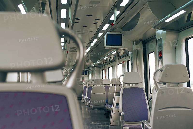 Discover the sleek interior of a modern train, featuring empty seats, soft ambient lighting, and clean design. Perfect for conveying travel or transport themes in any project