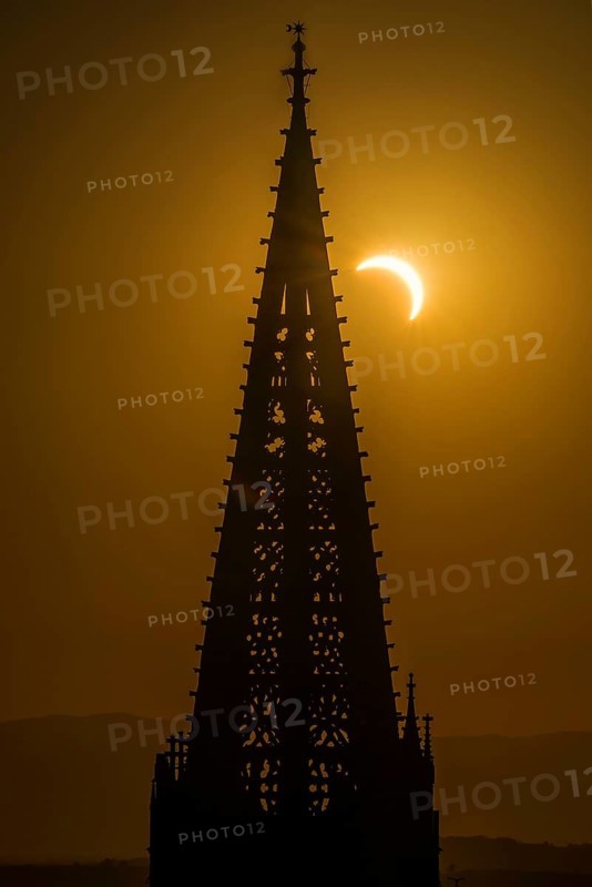Partial solar eclipse August 2026 and the tower of Freiburg Minster, sunset, Freiburg im Breisgau, Black Forest, Baden-Württemberg, southern Germany, Germany