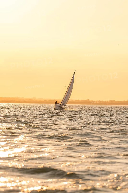 A sailboat at dawn, soft light and calm sea, Howth, Ireland