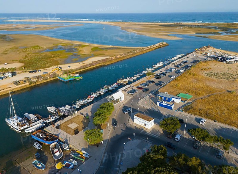 Harbour town with boats and a river flowing into the sea, lined with car parks and buildings, aerial view, Fuseta, Fuzeta, Faro, Algarve, Portugal