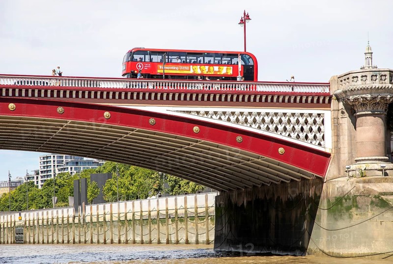 Red double-decker bus crossing Blackfriars Bridge, view from River Thames, London, England, UK