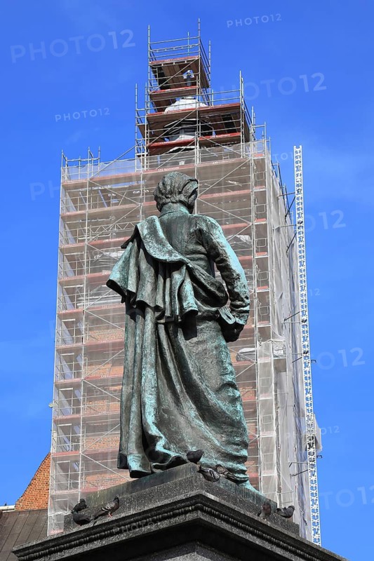 Picture shows the bronze statue of Polish poet Adam Mickiewicz on the main square with a view of St. Mary's Basilica, which in this picture is equipped due to renovation work on its tower, Krakow, Poland