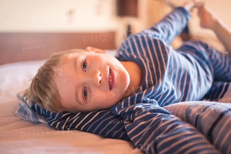 Five years old smiling in the bed after wake up