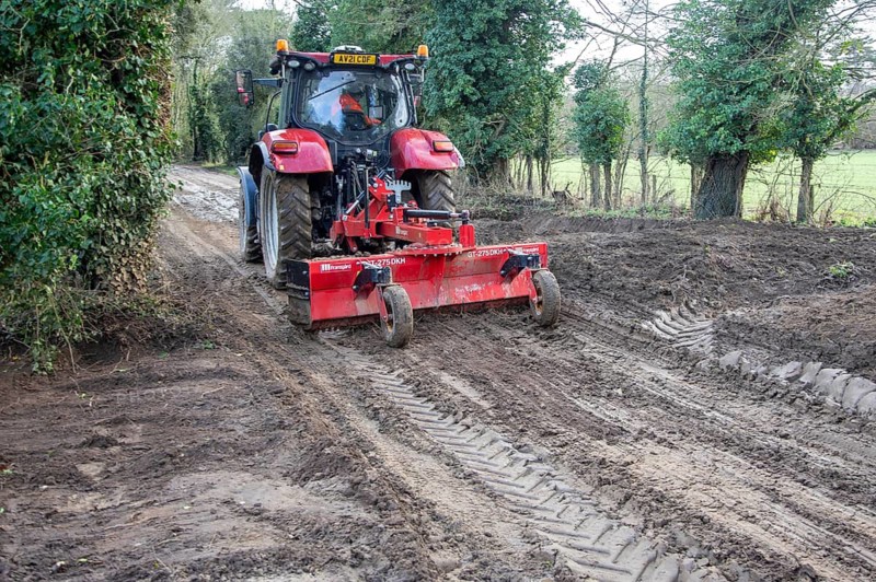 Tractor grading and levelling work repair a muddy, flood-prone country lane, Sutton, Suffolk Sandlings, Suffolk, England, UK