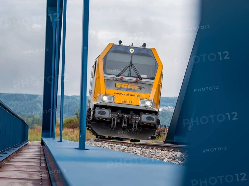 The driving trailer of a train on rails flanked by a blue bridge, track construction, rail delivery for Hermann Hessebahn, Calw, Black Forest, Germany