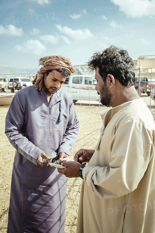 Camel dealer with customer, camel souk Salalah, Dhofar, Oman