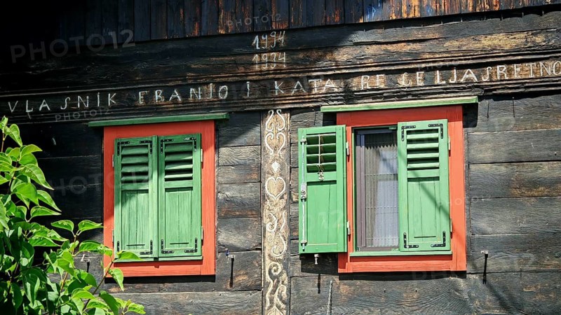 Old traditional wooden house with green shutters and antique lettering, rustic and historic setting, Croatia