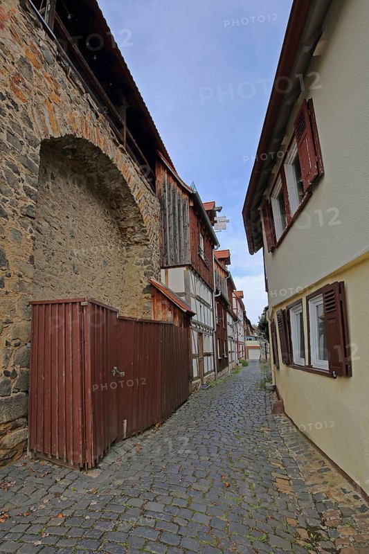 Historic arched houses, town wall with battlements, narrow alley with houses, Butzbach, Wetterau, Hesse, Germany