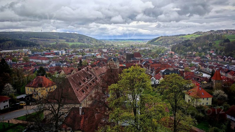 View from the fortress over Kronach with surrounding green hills in spring and cloudy sky, Veste Rosenberg, Kronach, Frankenwald nature park Park, Upper Franconia