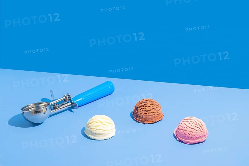 Three scoops of ice cream in chocolate, strawberry, and vanilla on a vibrant light blue and blue dual-tone background, accompanied by a blue-handled metal scoop