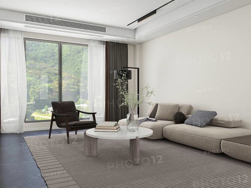 Elegant modern living room featuring a large window with a scenic view. The room is decorated with light furniture, a cozy rug, and decorative accents, creating a tranquil space