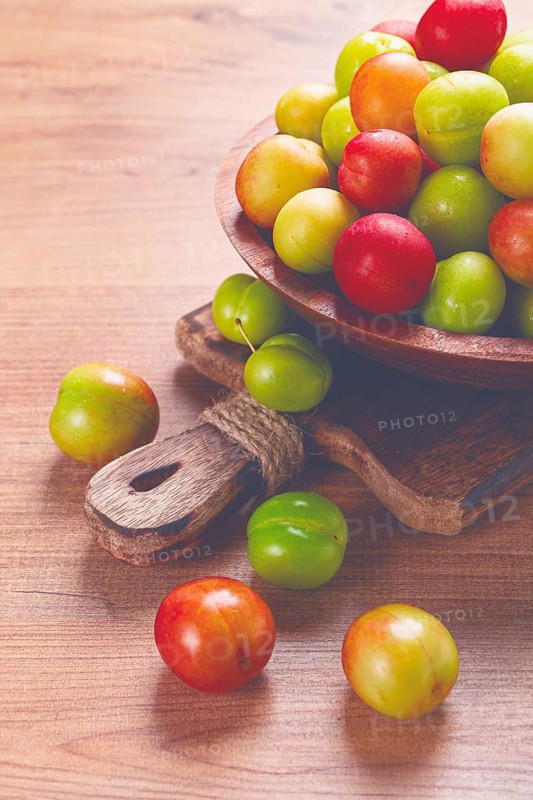 Cherry plum tkemali, fruit, plum variety, in a wooden plate, Georgian cuisine, top view, no people