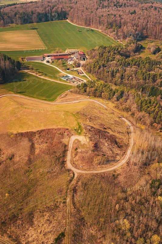 Aerial view of a hilly area with fields, a building and a winding path surrounded by forest, old deposit in front of PV Bau, Lindenrain, Calw, Germany