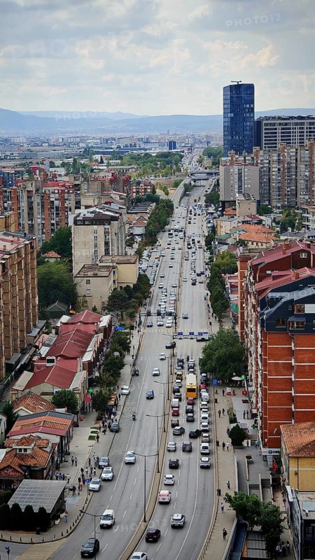 Main street in a city seen from above with heavy traffic and surrounding buildings, Pristina, Kosovo