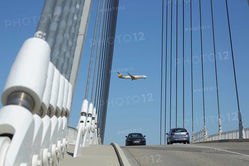 Air traffic and road traffic across the suspension rope bridge with pylon, ropes and white clamping sleeve, bolts, metal construction, sleeves, bridge pillars, passenger plane, road, cars, Raunheim, Hesse, Germany