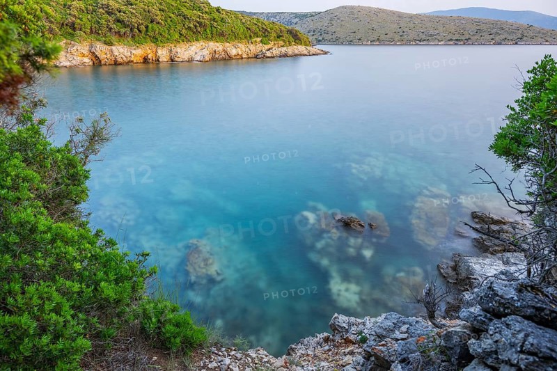 Crystal clear and turquoise water on the beach of Ustrine Bay on a sunny day at sunset on the island of Cres, long exposure, Croatia