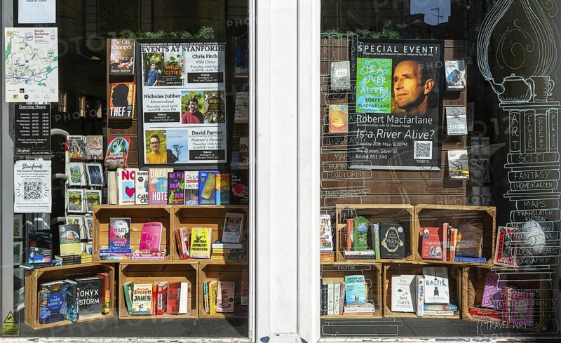 Window display of books and events, Stanfords bookshop, Corn Street, city centre of Bristol, England, UK