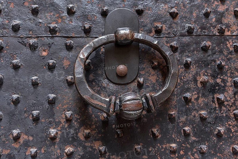 Door knocker on a historic iron door in the old town centre, Genoa, Italy