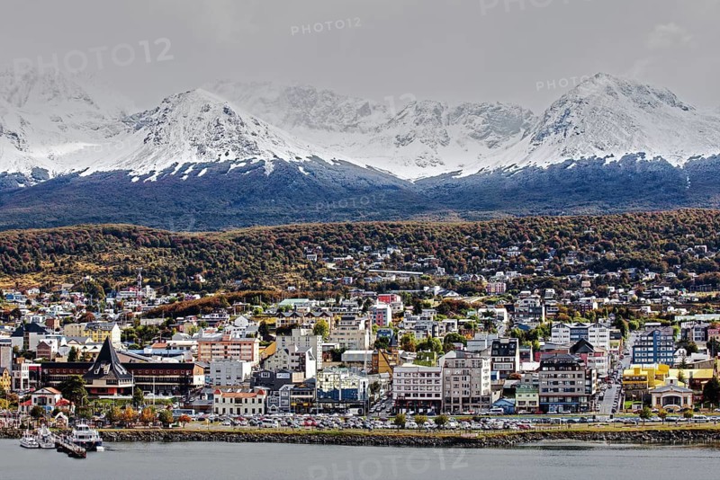 Picturesque view of the city of Ushuaia on the shore with snow-capped mountains in the background and a cloudy sky, Ushuaia, Argentina