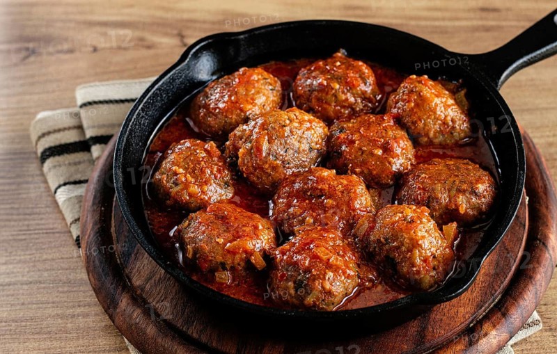 Minced meat meatballs, in tomato sauce, in a cast-iron pan, homemade, no people