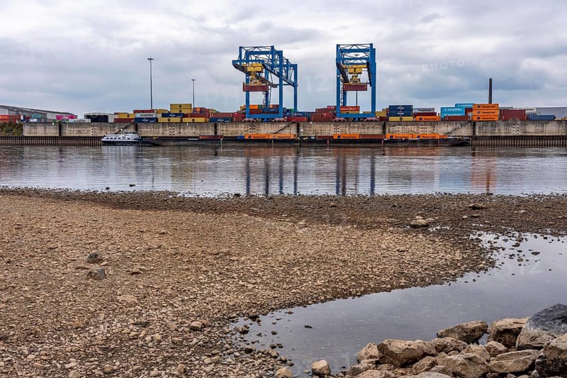 Extreme low water in the Rhine, the du-Ruhrort level was 130 cm at the time of recording, the lowest water level so far in 2018 was 153 cm, container loading in the container handling center, gateway west terminal, logport 2, RRT Rhine-Ruhr terminal, cargo ships on the Rhine only travel with a significantly reduced load, view from Rheinhausen du-Friemersheim to Duisburg-Wanheim, North Rhine-Westphalia, Germany