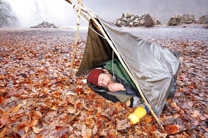 Nature photographer in a makeshift night camp on autumn leaves in spring, bad weather, Saxon Switzerland, Elbe Sandstone Mountains, Saxony, Germany