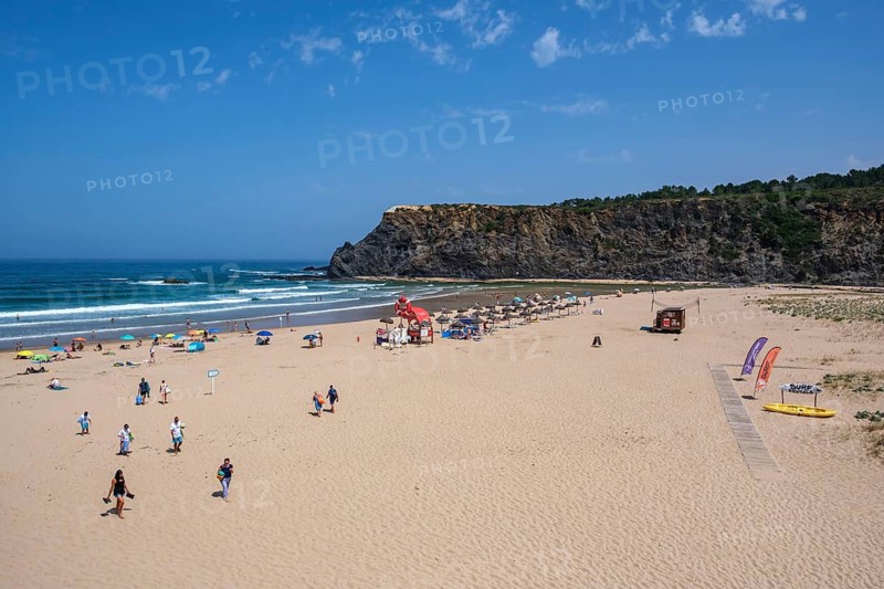 Extensive beach with cliffs in the background and people enjoying the summer weather, Odeceixe, Faro, Portugal