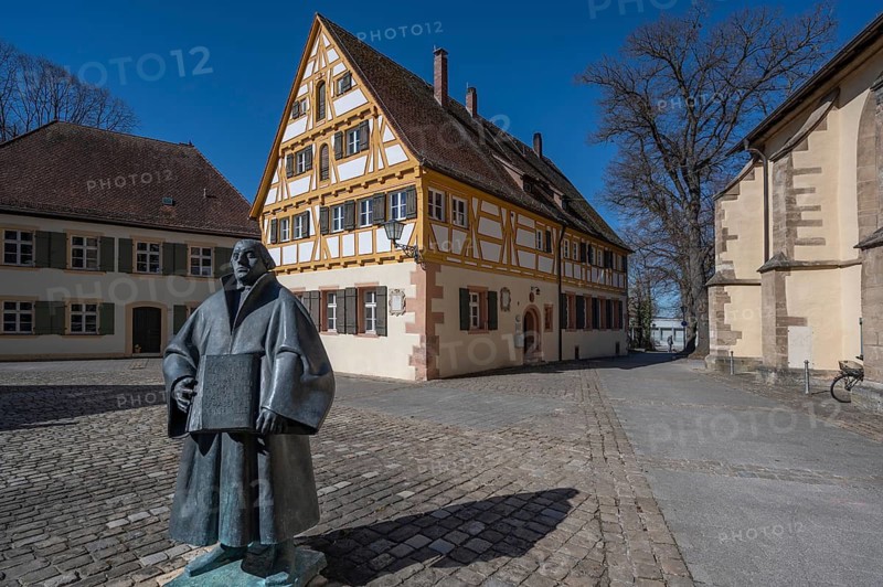 Luther sculpture, designed by Munich artist Martin Mayer, behind the former Latin school built in 1780, today part of the Protestant Community Centre, Martin-Luther-Platz 9, Weißenburg, Middle Franconia, Bavaria, Germany
