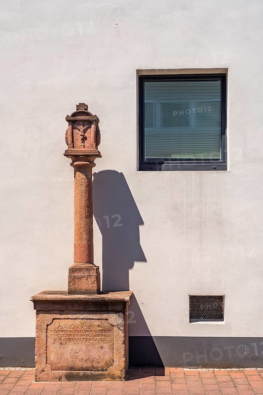 Red sandstone wayside shrine in front of a white façade in Goldbach, Aschaffenburg, Spessart, Lower Franconia, Bavaria, Germany