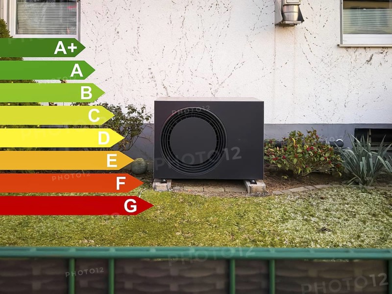 A black heat pump with efficiency classes according to the GEG in a front garden in Langenfeld, Germany
